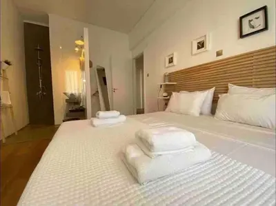 a bedroom with a large white bed with towels on it at Harmony Luxury Grand Suite in Athens