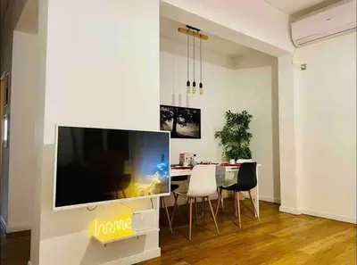 a living room with a large television and a dining table at Harmony Luxury Grand Suite in Athens