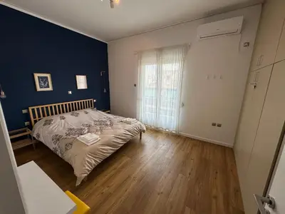 a bedroom with a bed and a blue wall at Harmony Luxury Grand Suite in Athens