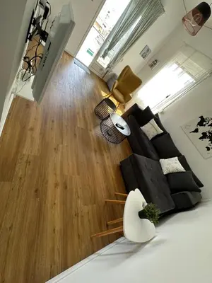 a living room with a bed and a wooden floor at Harmony Luxury Grand Suite in Athens