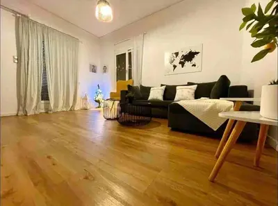 a living room with a black couch and a wooden floor at Harmony Luxury Grand Suite in Athens