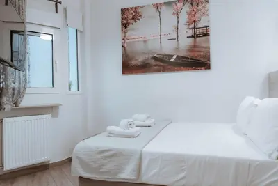 a white room with a bed and a picture on the wall at Acropolis Museum Stylish Apartments in Athens