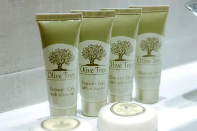 a group of four bottles of olive tree shower cream at Acropolis Museum Stylish Apartments in Athens