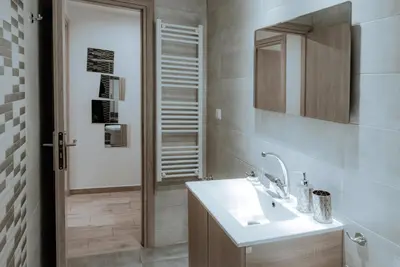 a bathroom with a sink and a mirror and a shower at Acropolis Museum Stylish Apartments in Athens