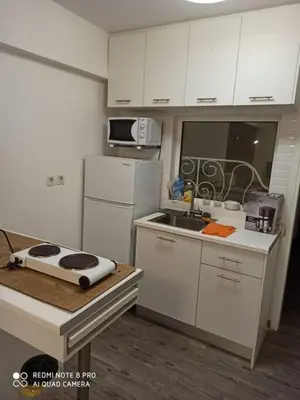 a small kitchen with white cabinets and a sink at A comfortable apartment to you in Athens
