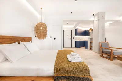 a bedroom with a white bed and a chair at Nana's Residence in Athens