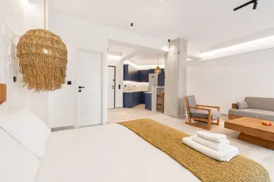 a white bedroom with a large bed and a couch at Nana's Residence in Athens