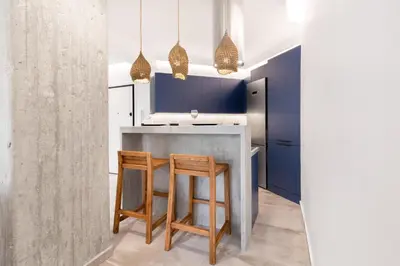 a kitchen with blue cabinets and two stools at Nana's Residence in Athens