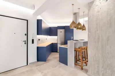 a kitchen with blue cabinets and a counter with a table at Nana's Residence in Athens