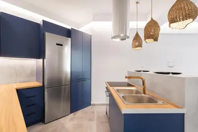 a kitchen with blue cabinets and a stainless steel refrigerator at Nana's Residence in Athens