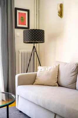 a living room with a white couch and a lamp at Acropolis, Falirou in Athens