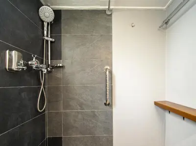 a shower in a bathroom with a gray tiled wall at Acropolis, Falirou in Athens