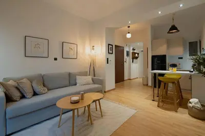 a living room with a blue couch and a table at The Heart Of Athens in Athens