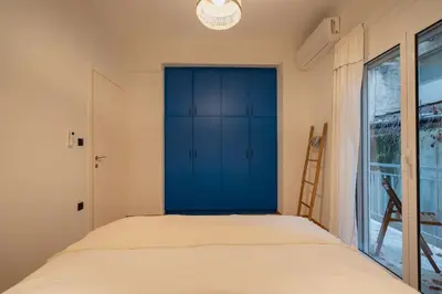 a bedroom with a blue cabinet and a window at The Heart Of Athens in Athens