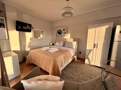 a bedroom with a bed and a tv in it at Top floor apartment in Athens
