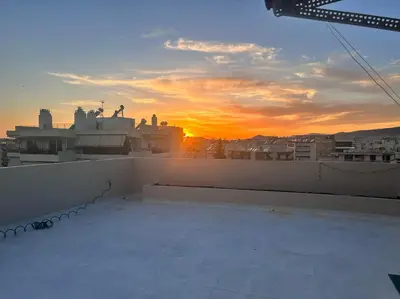 a view of the sunset from the roof of a building at Top floor apartment in Athens