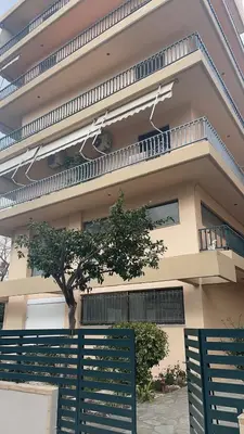 a building with a tree in front of it at Top floor apartment in Athens
