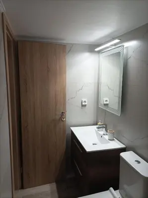a bathroom with a sink and a mirror and a toilet at Calypso in Athens