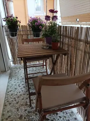 a table and chairs with potted plants on a balcony at Calypso in Athens