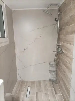 a bathroom with a shower with a marble wall at Calypso in Athens