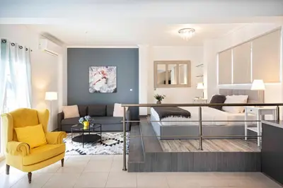 a living room with a bed and a yellow chair at Mirabella spacious studio in Athens