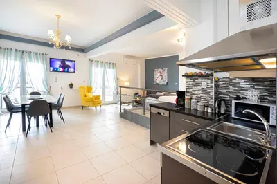a kitchen and living room with a table and a couch at Mirabella spacious studio in Athens