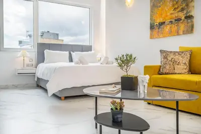a bedroom with a bed and a yellow couch at Olvar Suites in Athens