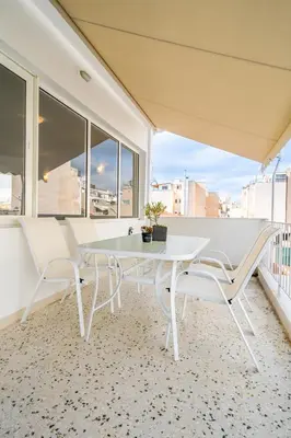 a white table and chairs on a balcony with windows at Olvar Suites in Athens