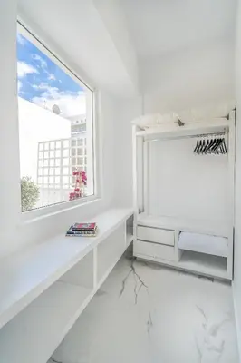 a white room with a window and a white table at Olvar Suites in Athens