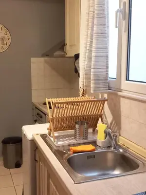 a kitchen sink with a wooden dish rack in it at Staying besides Acropolis! in Athens