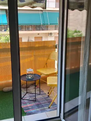 a patio with a table and a chair through a window at Staying besides Acropolis! in Athens