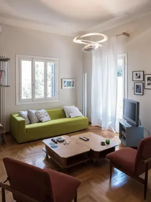 a living room with a green couch and a coffee table at 90m2 lovely 1-bedroom apartment in Paleo Faliro in Athens