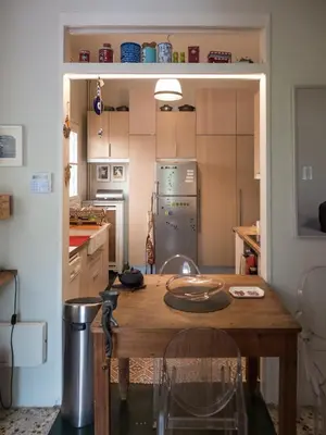 a kitchen with a wooden table and a refrigerator at 90m2 lovely 1-bedroom apartment in Paleo Faliro in Athens