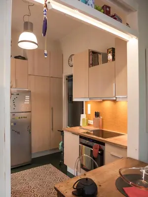 a kitchen with white cabinets and a wooden table at 90m2 lovely 1-bedroom apartment in Paleo Faliro in Athens