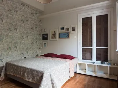 a bedroom with a bed and a wall with pictures at 90m2 lovely 1-bedroom apartment in Paleo Faliro in Athens