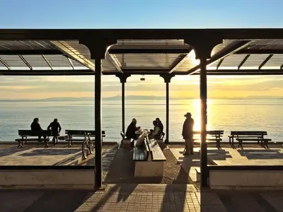 a group of people sitting on a pier near the water at 90m2 lovely 1-bedroom apartment in Paleo Faliro in Athens