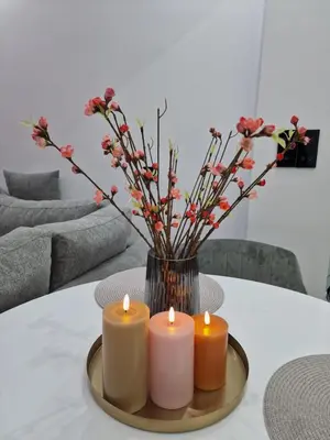 a table with three candles and a vase with flowers at Luxury apartment in Attiki in Athens