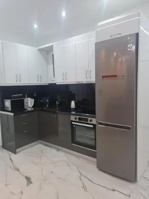 a kitchen with stainless steel appliances and black and white cabinets at Luxury apartment in Attiki in Athens