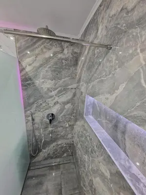 a bathroom with a shower with a stone wall at Luxury apartment in Attiki in Athens