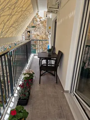 a balcony with a table and some flowers at Luxury apartment in Attiki in Athens