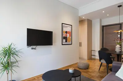 a living room with a tv on a white wall at Callirhoē Luxury 2BD Acropolis Apartment in Athens