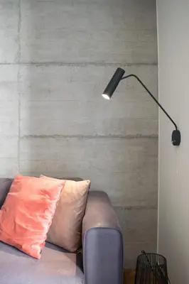 a lamp sitting next to a couch with a pillow at Callirhoē Luxury 2BD Acropolis Apartment in Athens