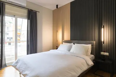 a bedroom with a large white bed with a window at Callirhoē Luxury 2BD Acropolis Apartment in Athens