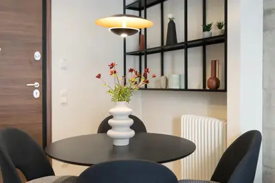a dining room table with a vase with flowers on it at Callirhoē Luxury 2BD Acropolis Apartment in Athens