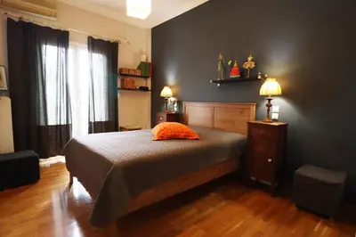a bedroom with a bed and two lamps on a wooden floor at Amazing penthouse in Ambelokipi in Athens