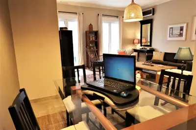 a laptop computer sitting on a glass table in a living room at Amazing penthouse in Ambelokipi in Athens