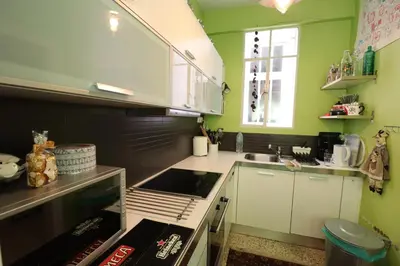 a kitchen with green walls and a stove top oven at Amazing penthouse in Ambelokipi in Athens