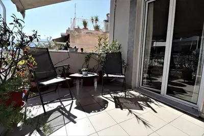 a patio with two chairs and a table on a balcony at Amazing penthouse in Ambelokipi in Athens