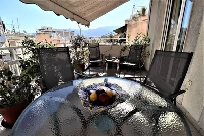 a glass table with a bowl of fruit on a balcony at Amazing penthouse in Ambelokipi in Athens
