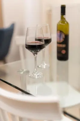 two glasses of red wine sitting on a table at LIV - Vintage Acropolis Apartment in Athens